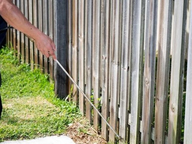Aplicación de tratamiento perimetral en el jardín de una vivienda