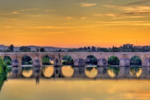 Puente romano de Córdoba reflejado en el Guadalquivir al atardecer
