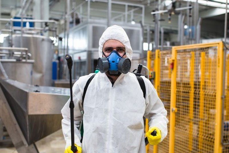 Técnico con máscara y buzo en una planta de procesado de Priego de Córdoba